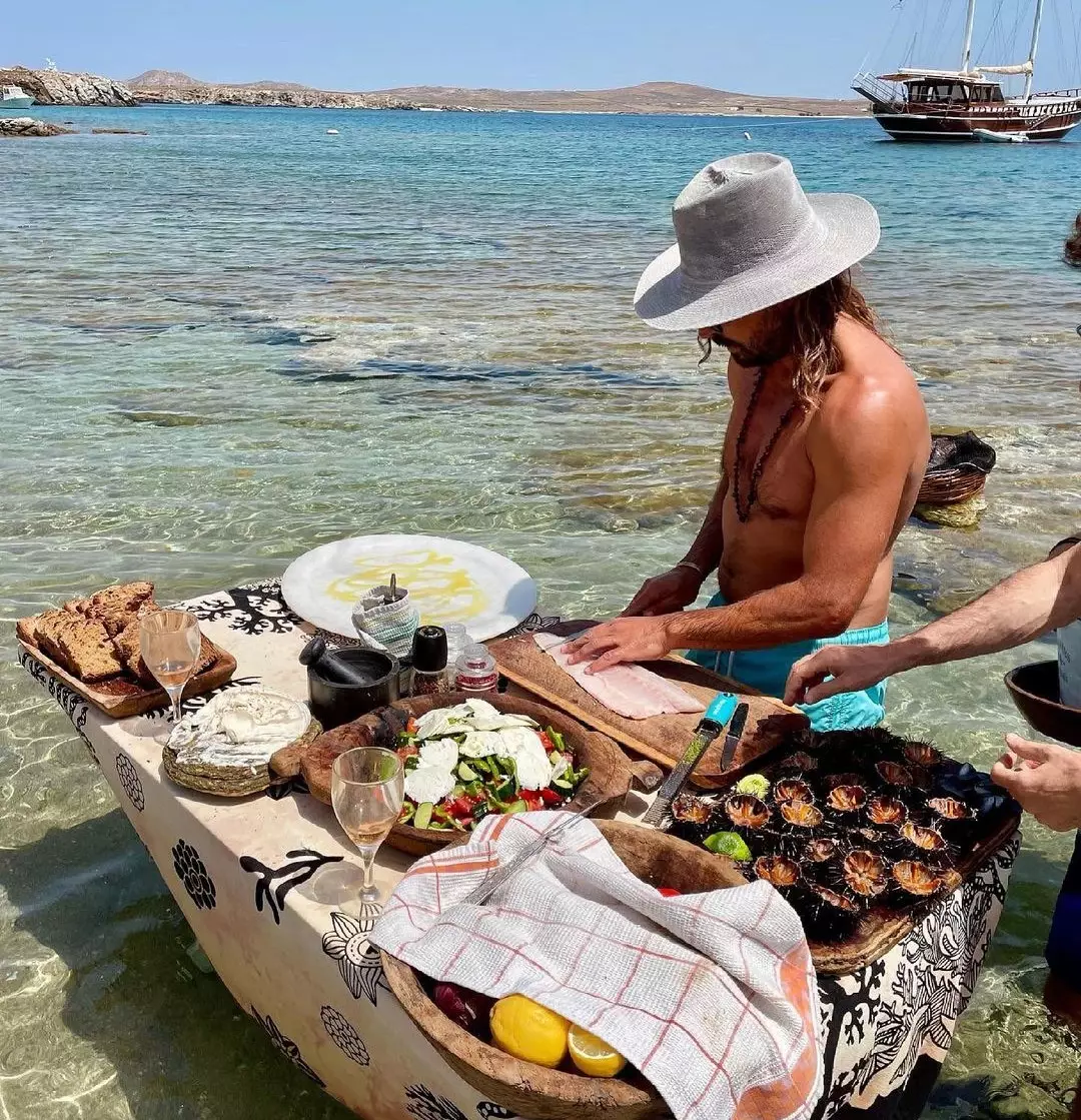 Luxury beachfront dining setup in Mykonos with a personal chef crafting gourmet dishes